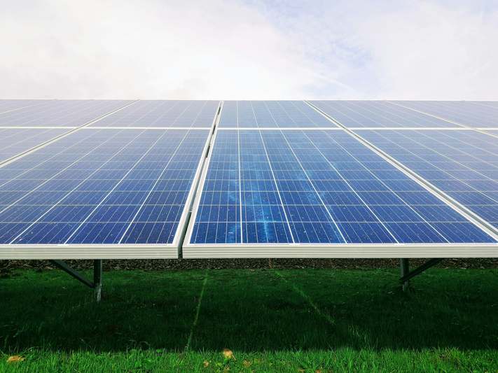 Stacked books titled 'Solar Energy Handbook' next to a modern inverter